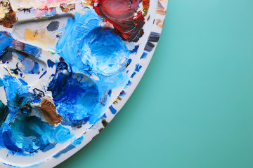 Palette with colored paints on a blue background