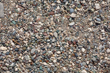 Sea shore. Pebble beach. Small colored sea stones close-up. Colored seabed. Summer holidays...