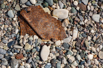 Stones texture. Background the damp multi-colored pebbles close up soft focus from on the pebbly beach in cloudy weather.
