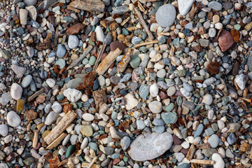 Stones texture. Background the damp multi-colored pebbles close up soft focus from on the pebbly beach in cloudy weather.