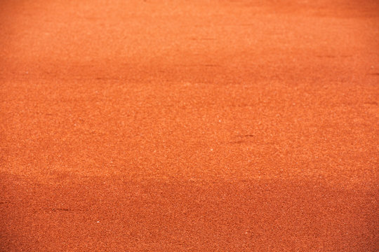 Red clay court tennis background texture. Tennis court close-up of gravel surface.