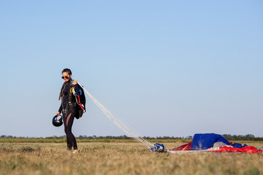Happy parachute girl jumper after landing.