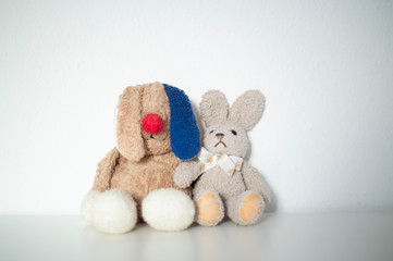 2 Kuscheltiere mit lustigen Ohren sitzen auf einer Kommode