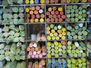 set of colorful pastels in a plastic box. objects for drawing. creativity. goods for artists. distribution by color tones.