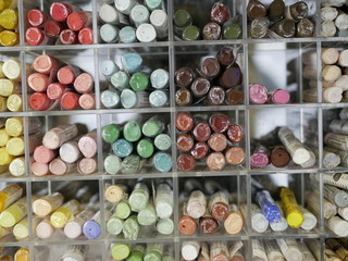 set of colorful pastels in a plastic box. objects for drawing. creativity. goods for artists. distribution by color tones.