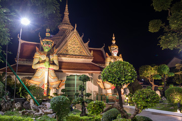 Naklejka premium Wat Arun Temple of Dawn Buddhist temple with guardians protecting gates. Bangkok, Thailand.