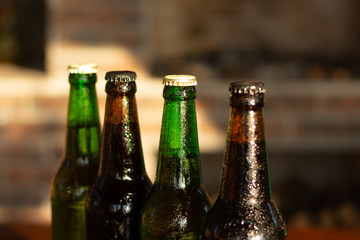top part of green and brown beer bottles closeup