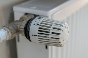 A thermostat on a heater is set to a medium level to save energy. Concept: heat or heating costs