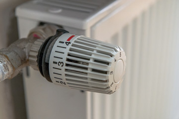 A thermostat on a heater is set to a high level. That causes high heating costs. Concept: save heat or energy