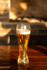 Glass of beer on wooden table, closeup.