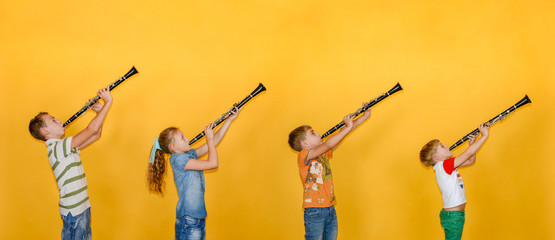 Four people, a musician, stand in a row and play clarinets, photos of children on a yellow background.