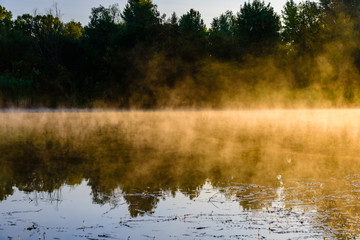 Fog above the water surface. Sunrise at river