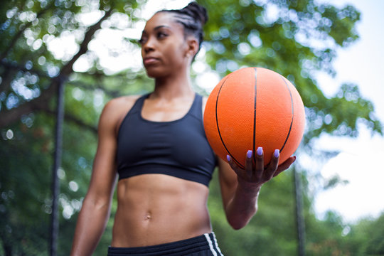 Close up view of woman holding basketball in her left hand