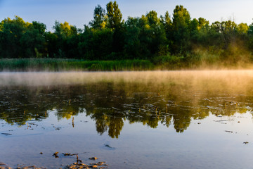 Fog above the water surface. Sunrise at river