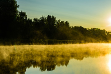 Fog above the water surface. Sunrise at river