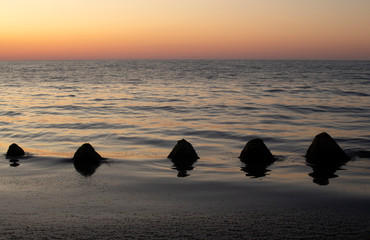 In the light of sunrise. Seascape with stones. On the beach for fishing in Krapets. Northern Black Sea Coast, Bulgaria.