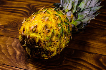 Ripe whole pineapple on a wooden table