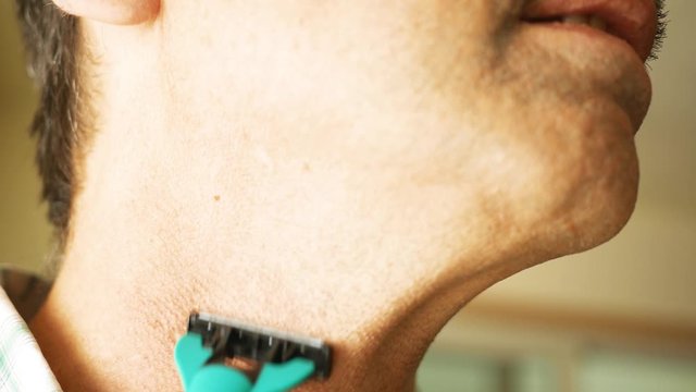 A father shaves with a dry straight edge razor