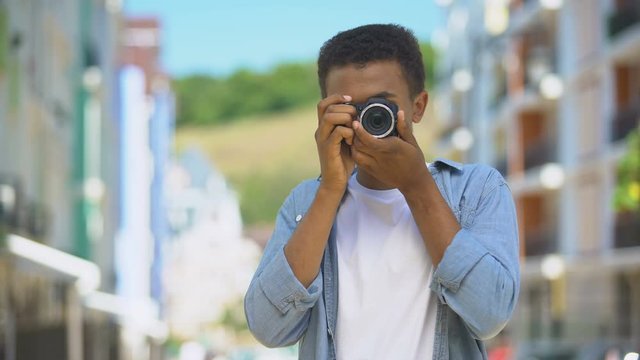 Young teen with camera making photos outdoor and smiling, hobby and rest