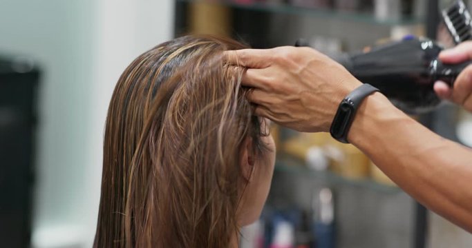 Woman blow air with hair dryer in salon