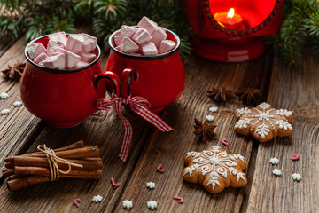 Two red cups with hot  drink and marshmallow with  gingerbread. Christmas concept with fir tree...