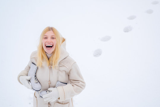 Beautiful happy laughing young woman wearing winter hat gloves and scarf covered with snow flakes. Winter game. Funny young woman in the winter time. Portrait of a happy teenage girl in the snow.