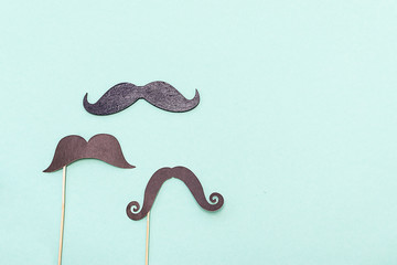 Men health awareness month. Old fashioned paper mustaches on light blue background. Template...