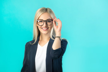 beautiful young woman in a black suit with glasses on a blue background