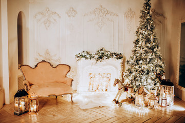 classical interior of a white room with a decorated fireplace, luxury Christmas tree, garlands, candles, lanterns, gifts. day golden pastel colors. new year