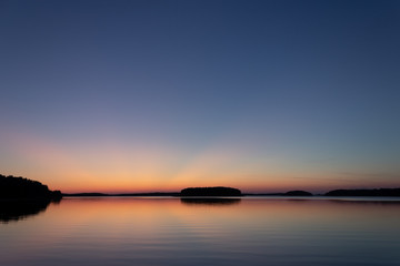 Rays of sunset over a Finnish lake