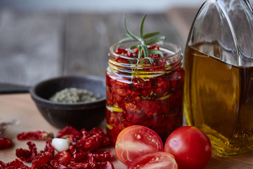 Sun-dried tomatoes with Provencal herbs, garlic and olive oil on a rustic wooden surface, selective...