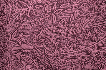 Texture of genuine leather close-up, burgundy purple color with embossed paisley trend pattern, for wallpaper or banner design
