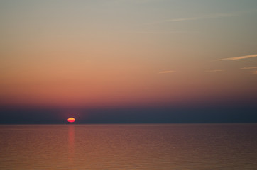 Sunset over sea on orange sky background