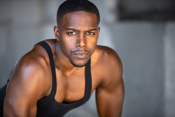 Fototapeta na wymiar Black athlete, fitness trainer portrait, muscular powerful expression headshot, urban workout