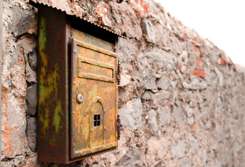 Old rusty mailbox on brick wall