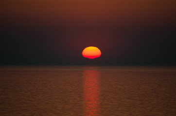 Obraz premium Sunset over sea on dark sky background