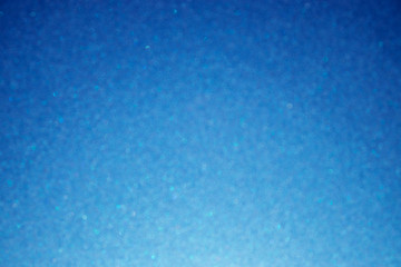 Blue glittering background; blured image with bokeh effect; selective focus