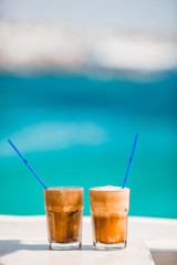Coffee latte on wooden table with sea background