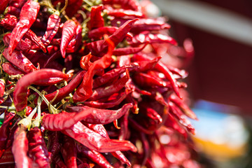 Dried red chilli paprika on a market stall with out of focus areas on the right.