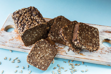 Rye yeast-free bread with sunflower seeds on a blue background.