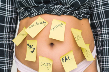 Overweight fat woman with a word Fat, ugly, lazy, pig, sick, strange, looser, unhealthy and thumb...