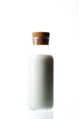 Bottle with milk on a white background. Glass bottle. Natural cork. White drink. Cow's milk.