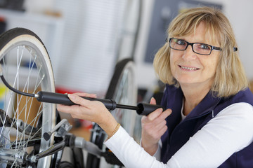 female mechanic fixing bicycle in workshop