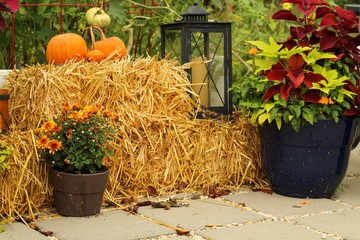 Outdoor Patio decorated for Autumn with pumpkins, pillows, plants and hay bales, lanterns