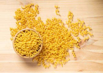 Raw yellow cavatappi pasta on wood table background