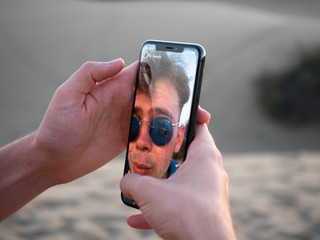 Young male users smartphone to take a selfie