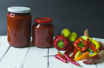 Fresh Ajvar made of tomatoes and paprika on the rustic wooden table.