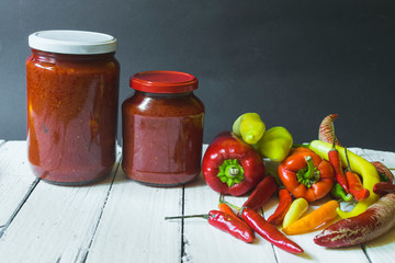 Fresh Ajvar made of tomatoes and paprika on the rustic wooden table.