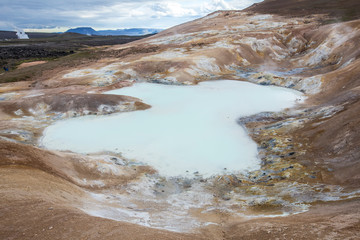 View with burning puddle of white water in the foreground in Hverir, Iceland
