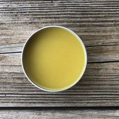Tin of balm on wooden background